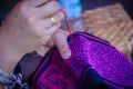Close up hand of Hmong woman is sewing traditional tribal clothe